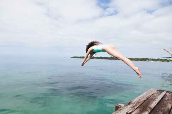 photo of woman diving into the water